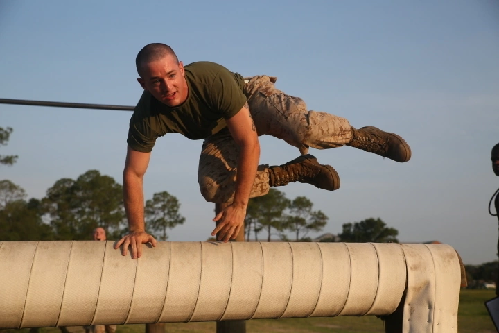 Marine jumping a barrier on an obstacle course