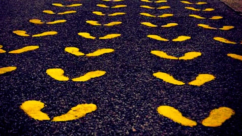 Yellow footprints on asphalt